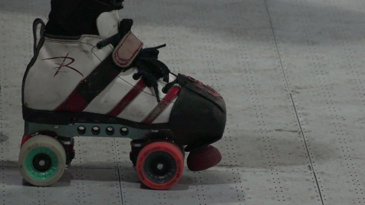 The Denver skate remains centered in profile, showing black laces, a white boot, red accents, and mismatched green and red wheels.