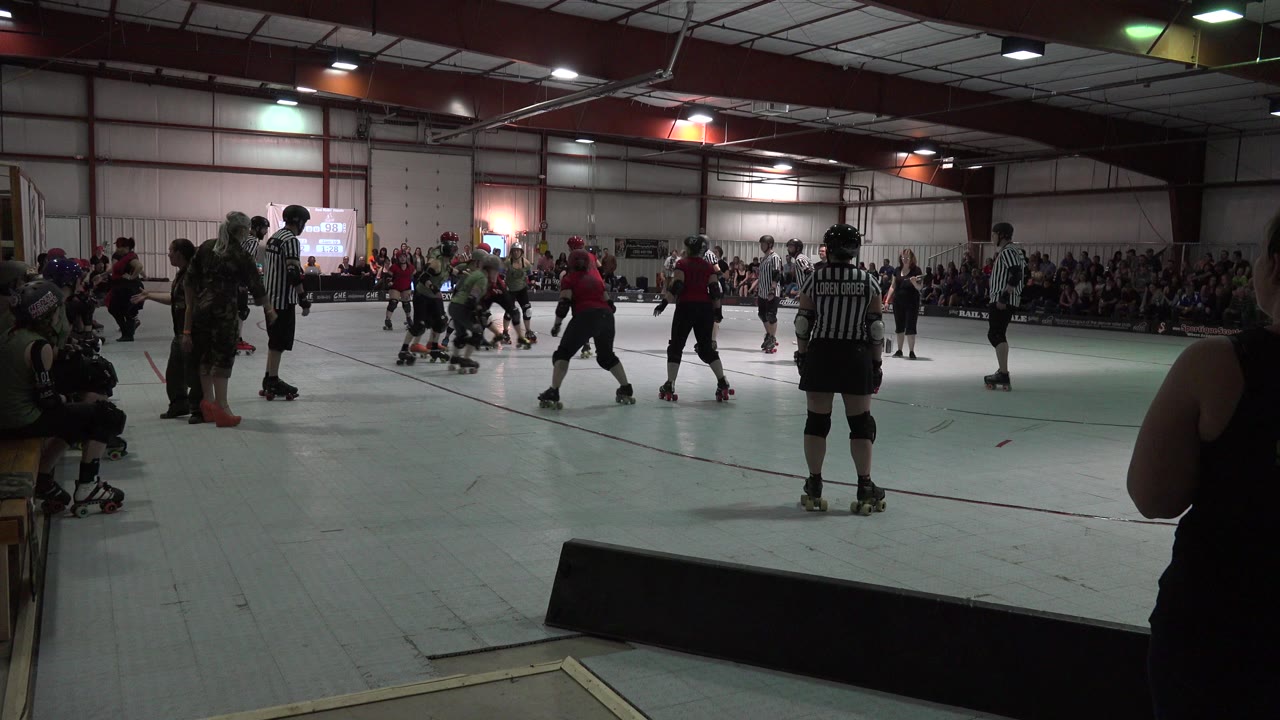 Roller derby skaters and referees on an indoor rink