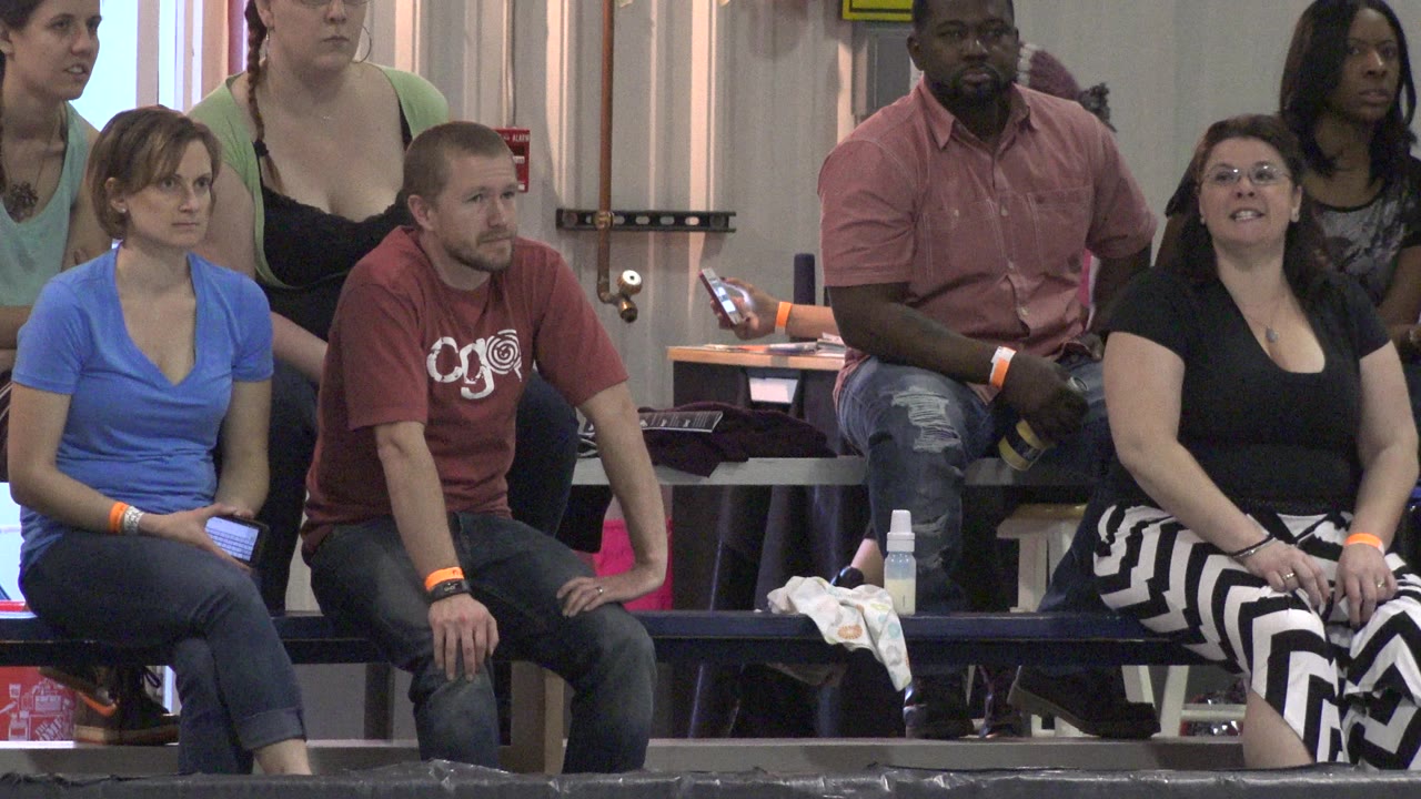 Spectators seated on bleachers beside a roller derby track.