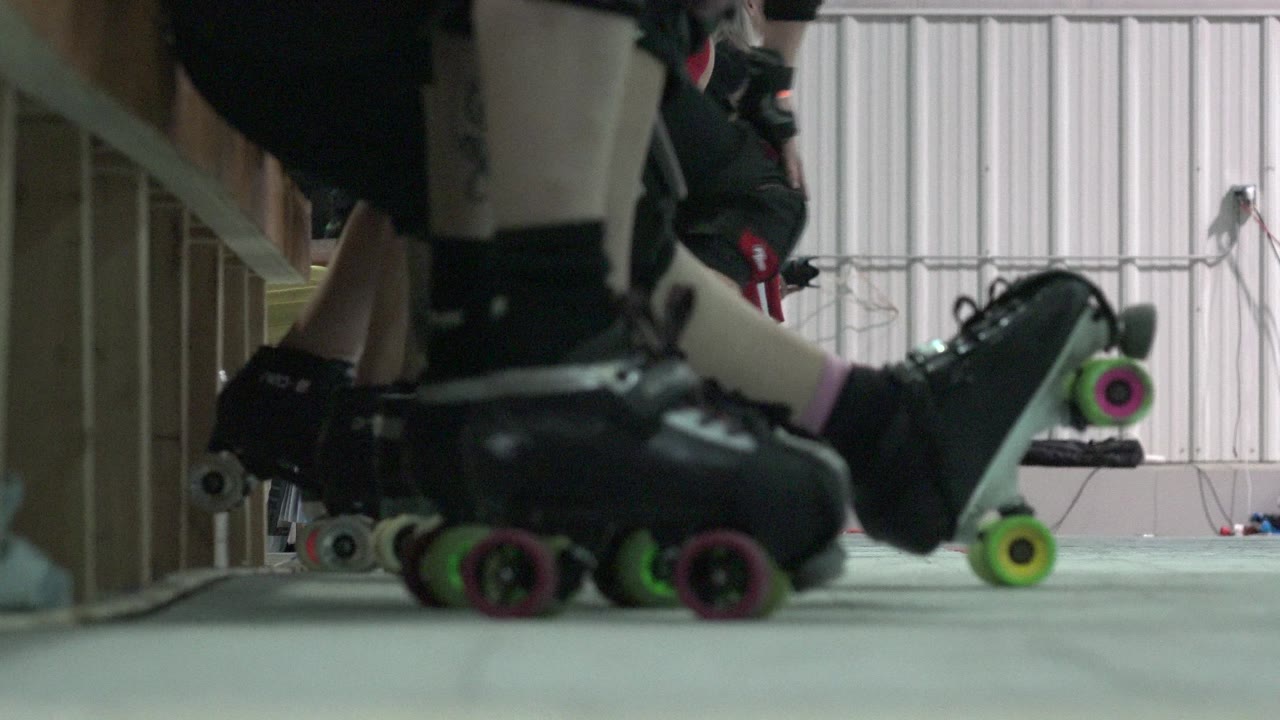 Low-angle view of roller skates beside a bench.