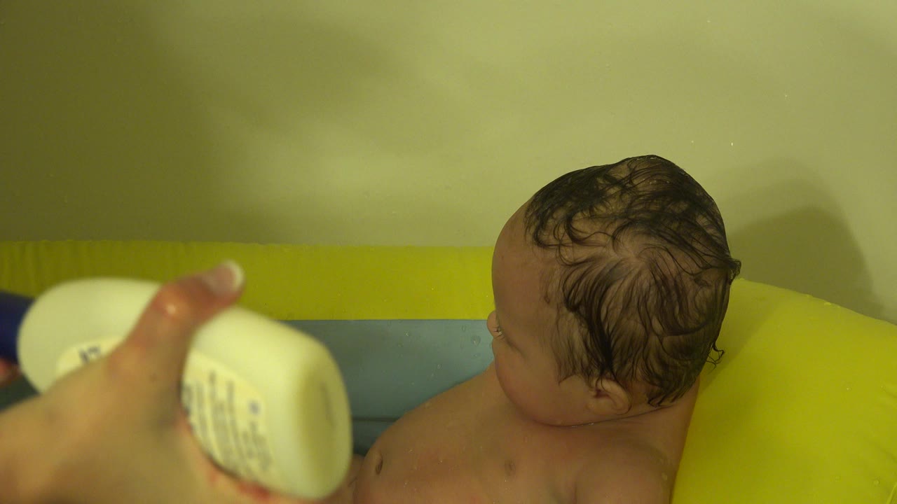 In Westminster, Colorado, the soap bottle remains in the foreground while the baby's wet hair and bare shoulders are visible in the bath.