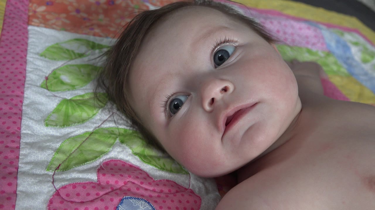 Baby lying on a pink and purple quilt