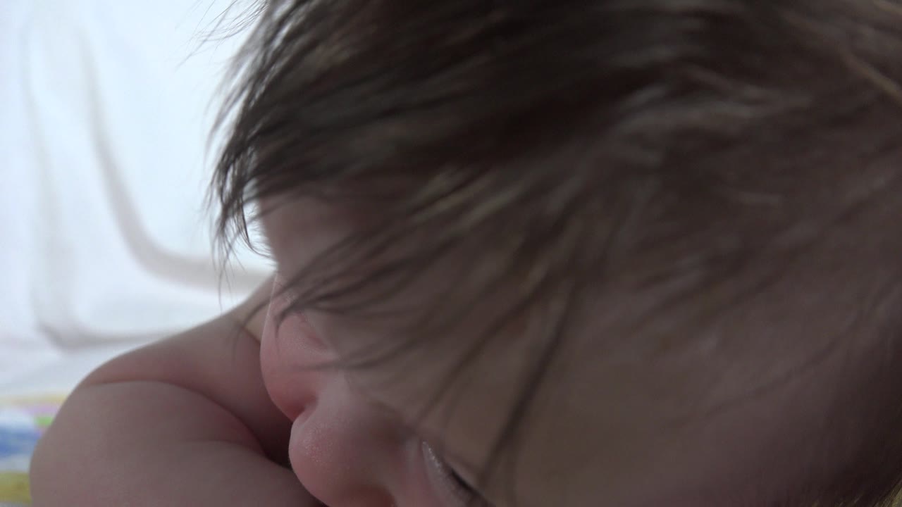 Infant face partly obscured by hair