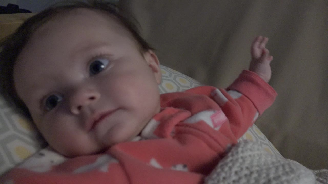 Infant in pink pajamas lying on a blanket