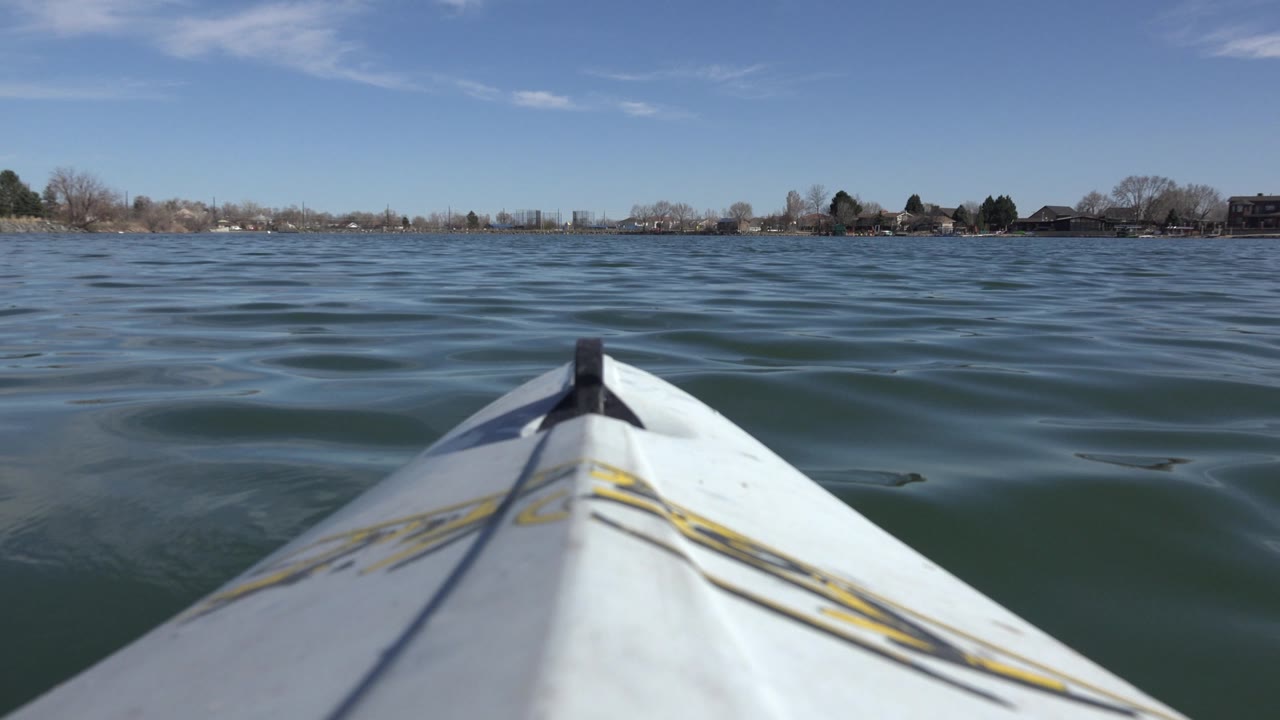 Kayak bow facing distant homes across calm lake