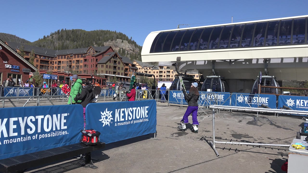 Keystone event barriers and skiers near a gondola station.