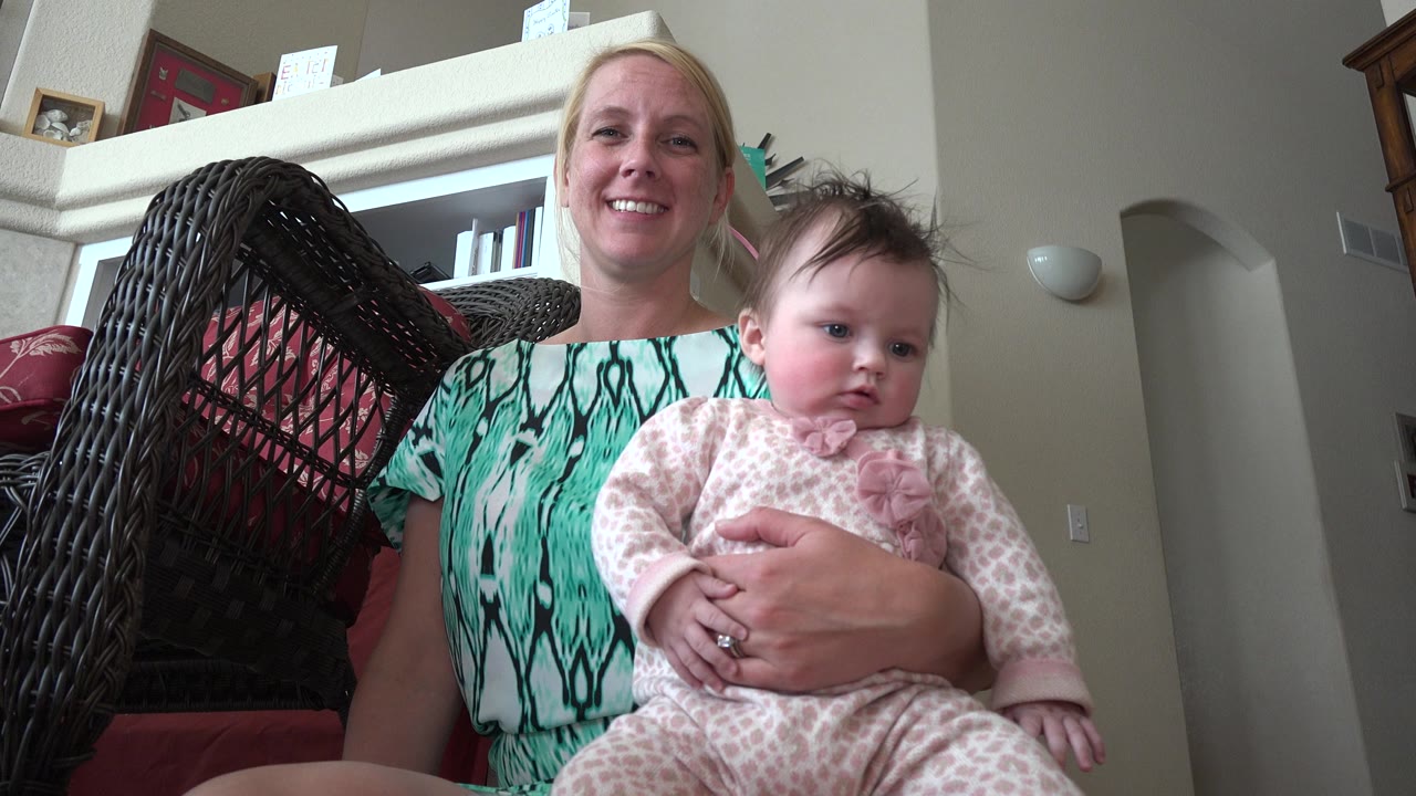 Woman holding a baby on her lap in a living room.