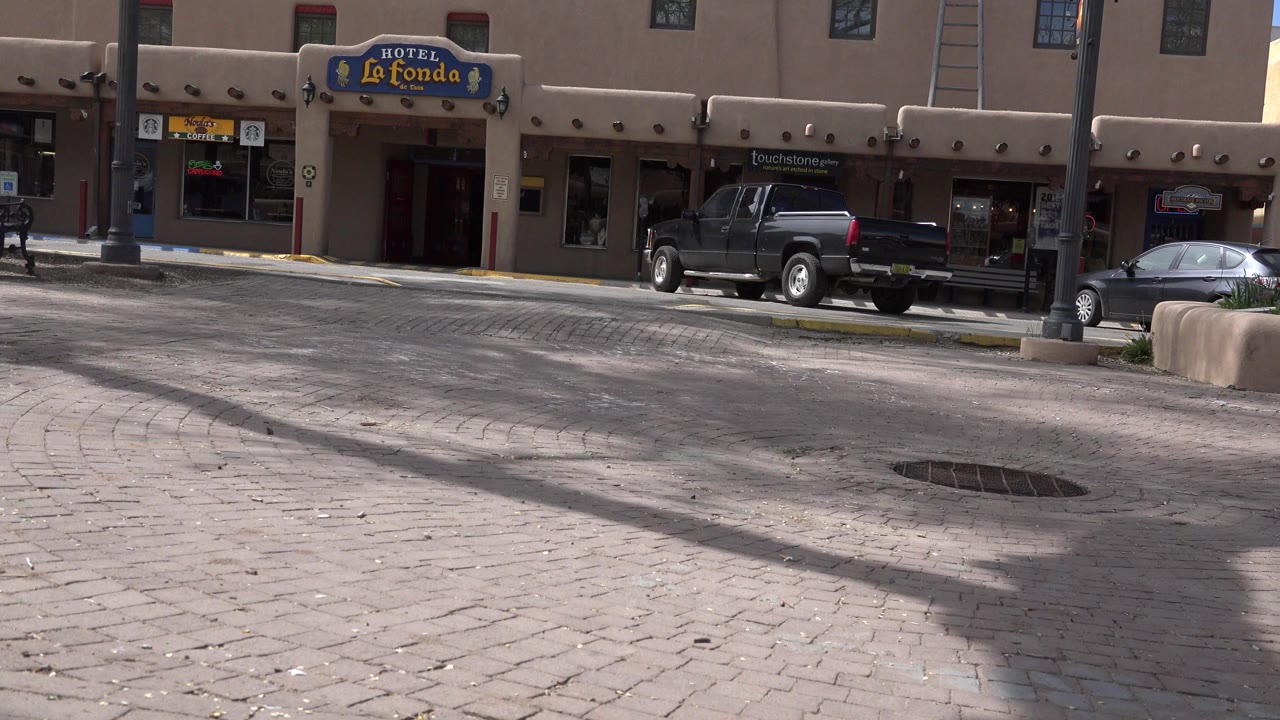 Hotel La Fonda facade across a paved street with parked vehicles