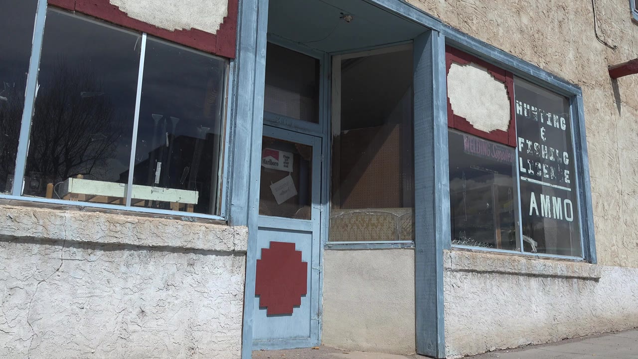 Weathered storefront with blue trim and glass windows.