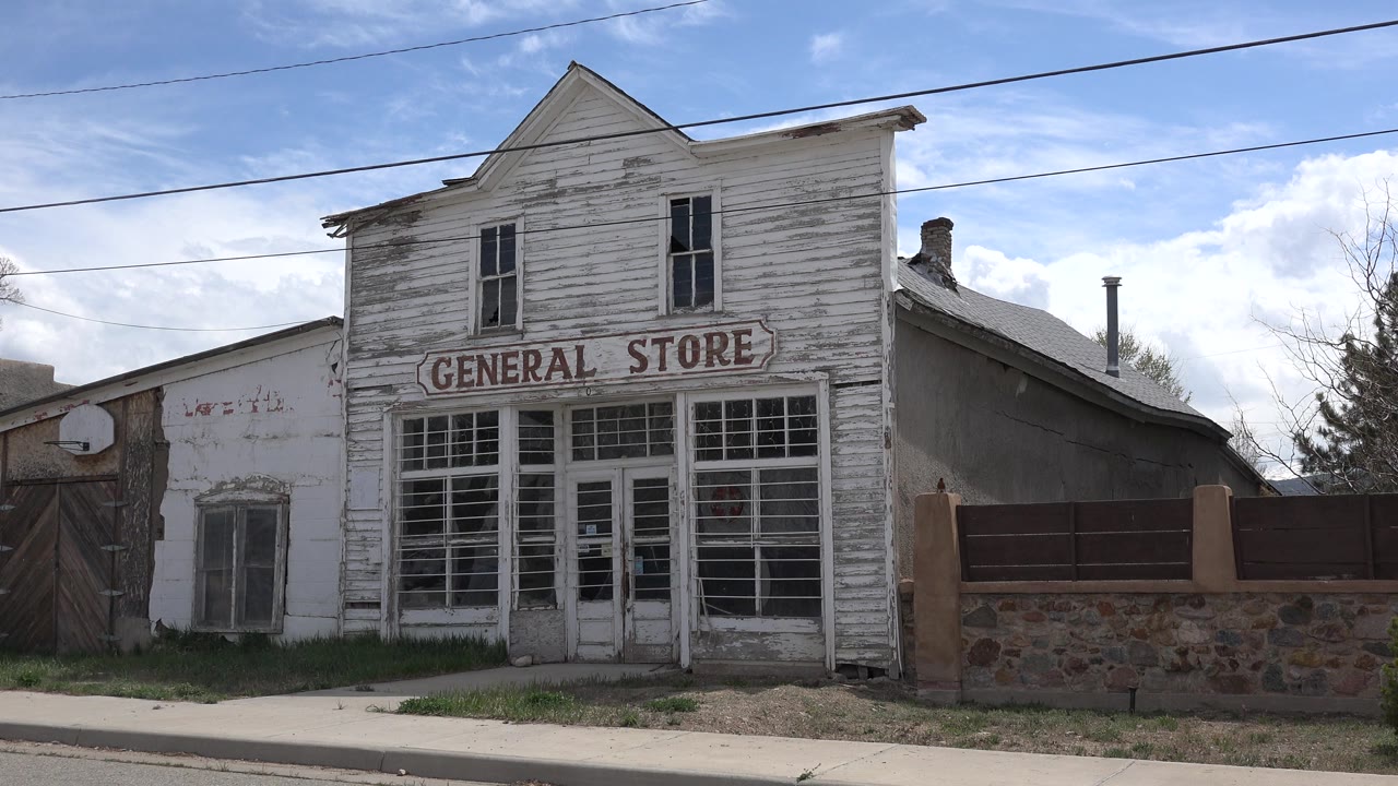Weathered general store facade beside a sidewalk