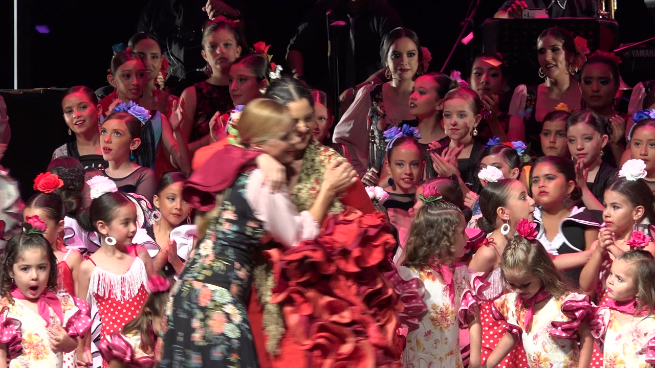 Women and children gathered on a stage during a performance event.