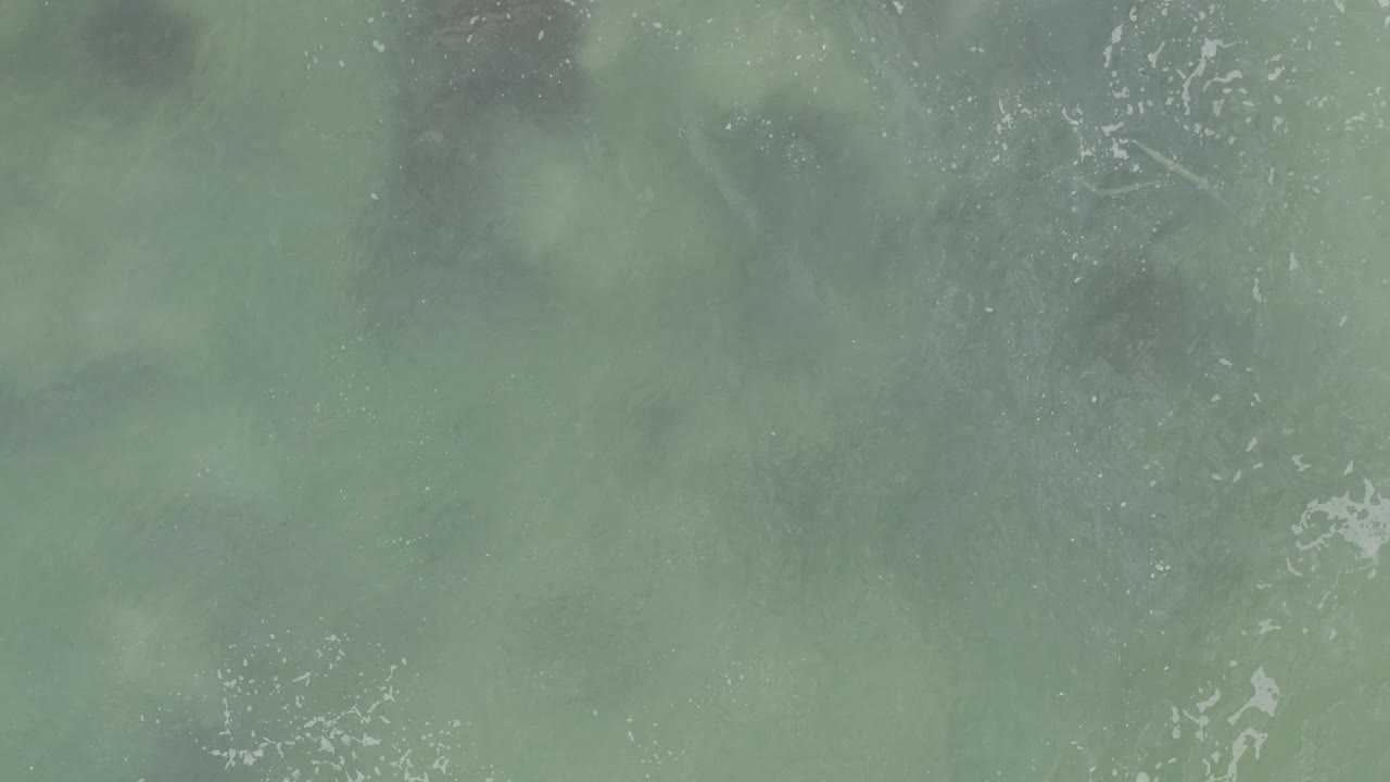 Aerial view of cloudy green ocean water in Baja California Sur, with small white wave marks and no visible people or vessels.