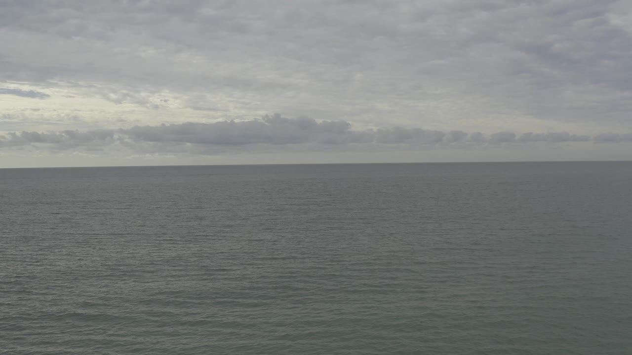 Overcast Baja California Sur ocean scene with a thin horizon band, gray sky, subdued water texture, and no visible people.