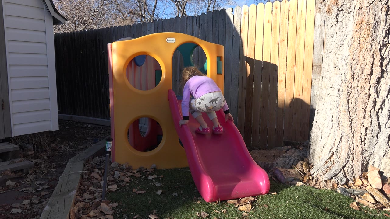 Toddler crouches near the top of the slide.