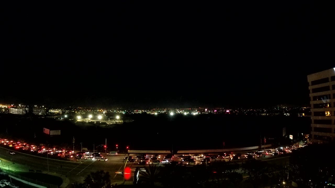 Wide dark city view with traffic lights running along the lower frame.