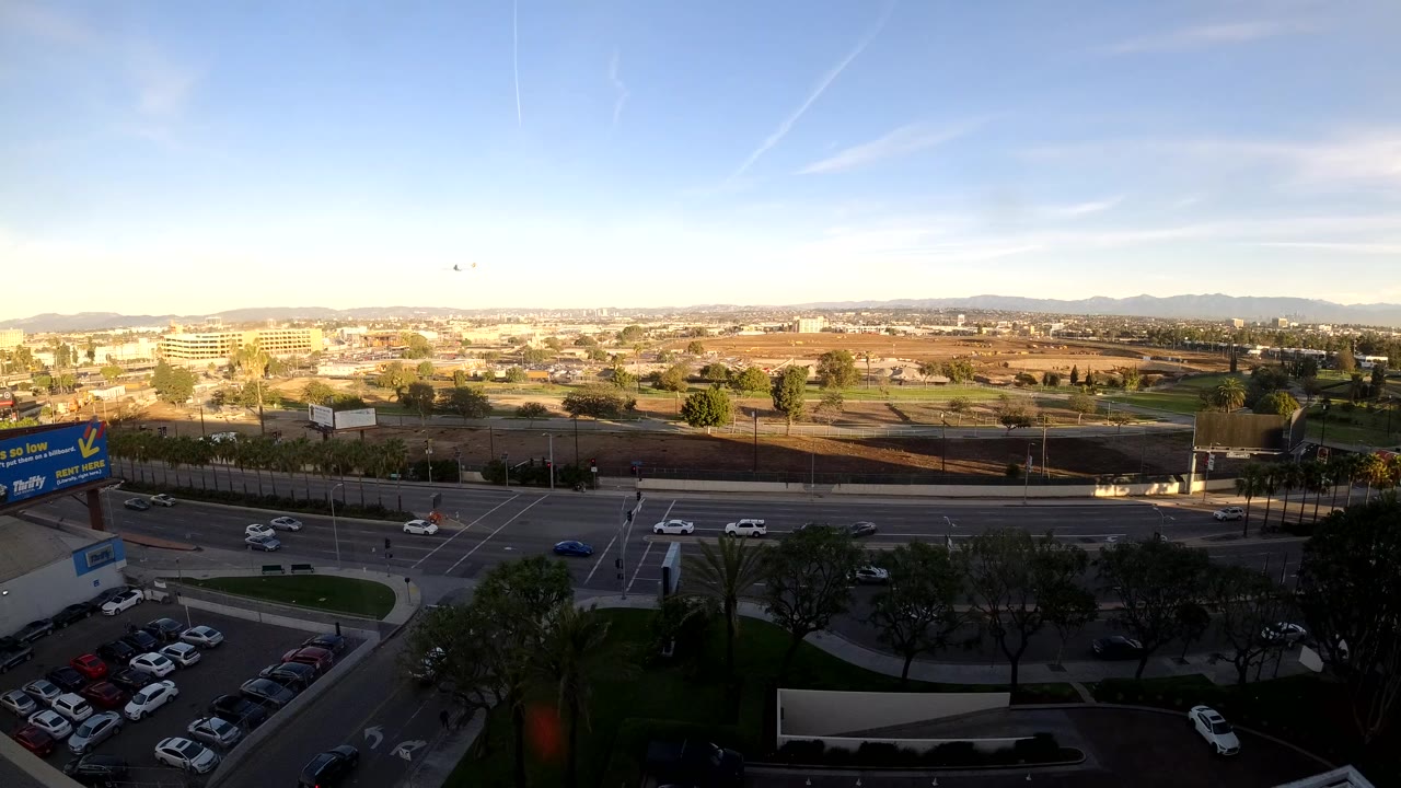 High city view with cars moving through a broad road corridor under clear sky.