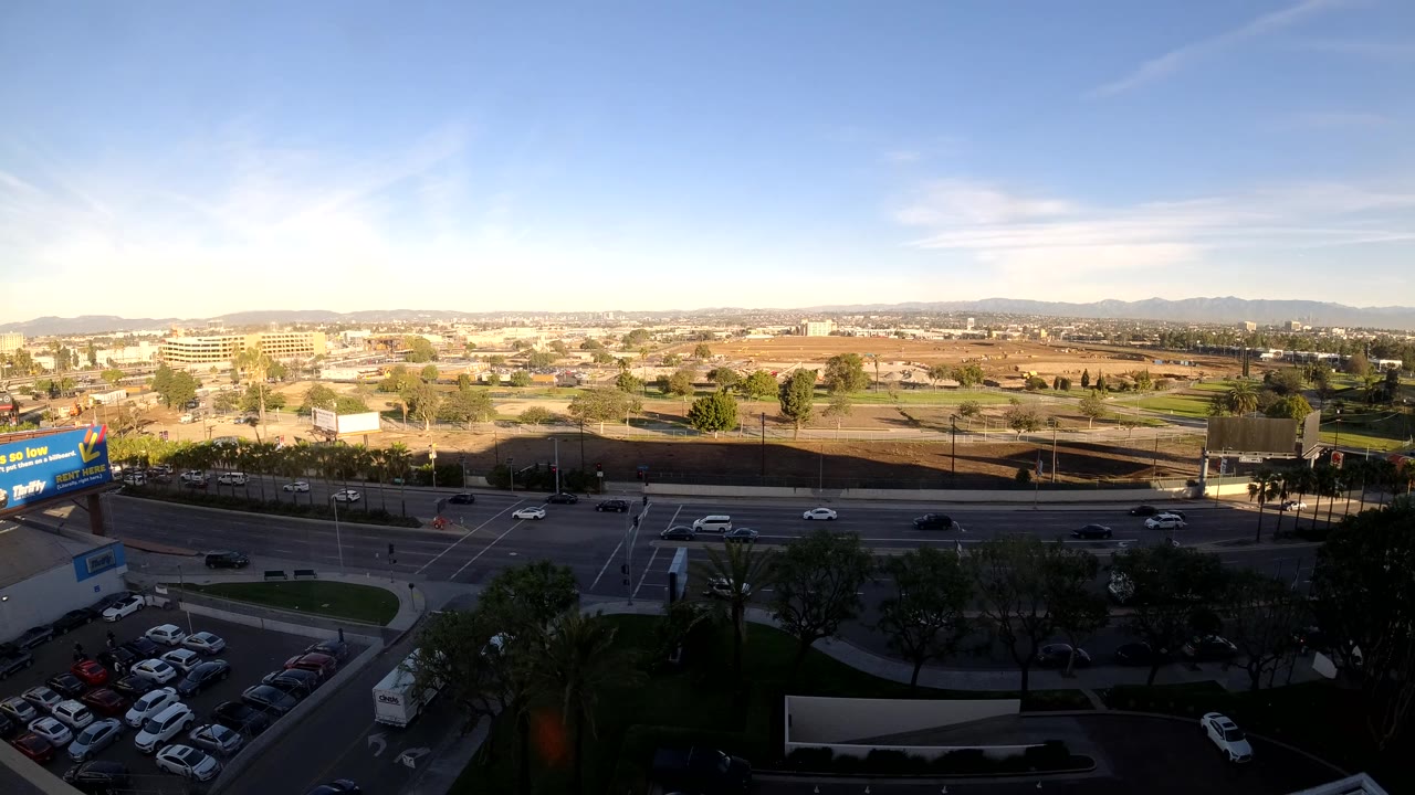 Wide elevated view of daytime road traffic with a shaded foreground.