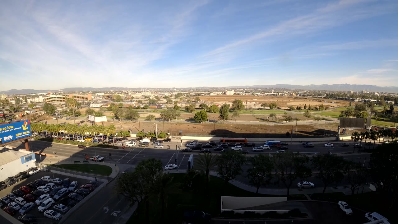 High daytime view of a road with cars and commercial blocks.