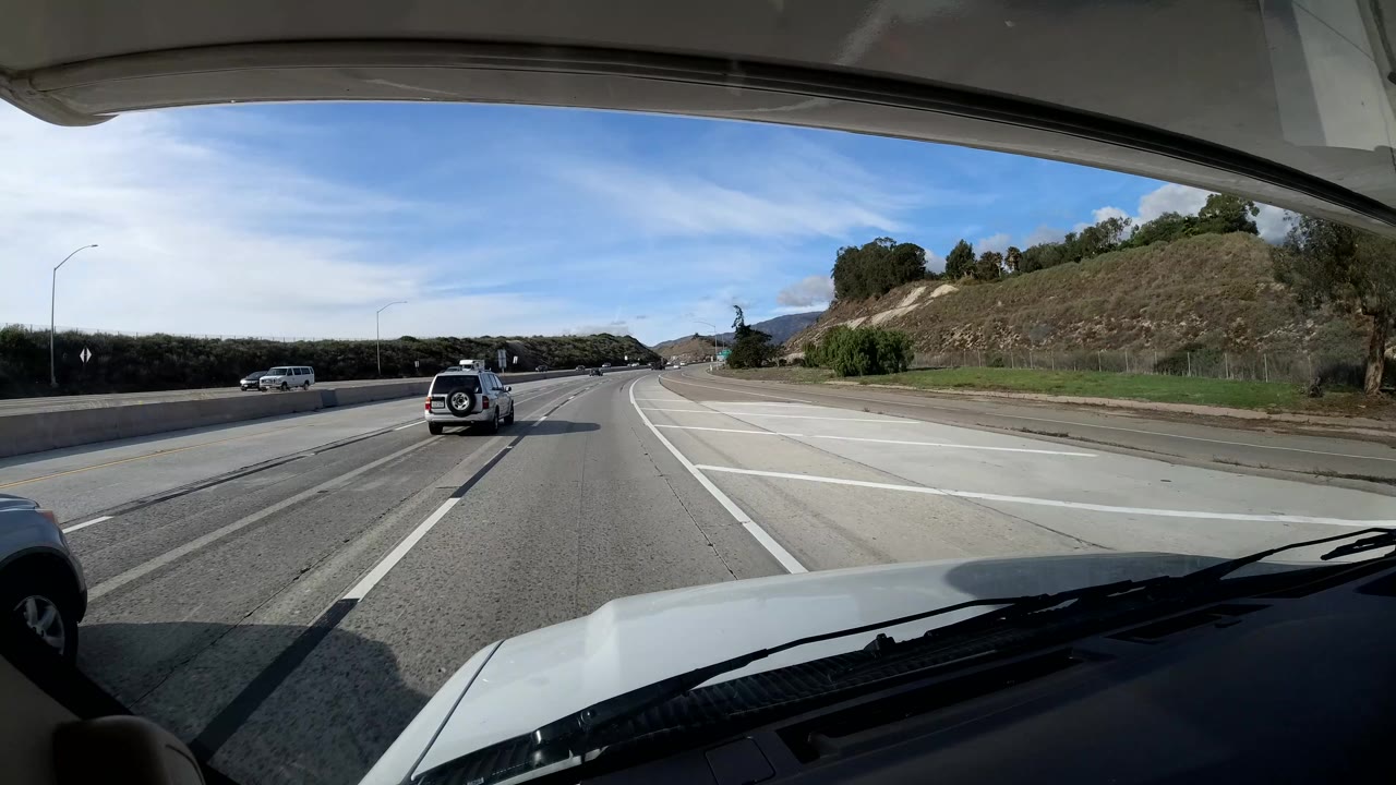 Vehicle perspective of highway lanes with a small SUV ahead