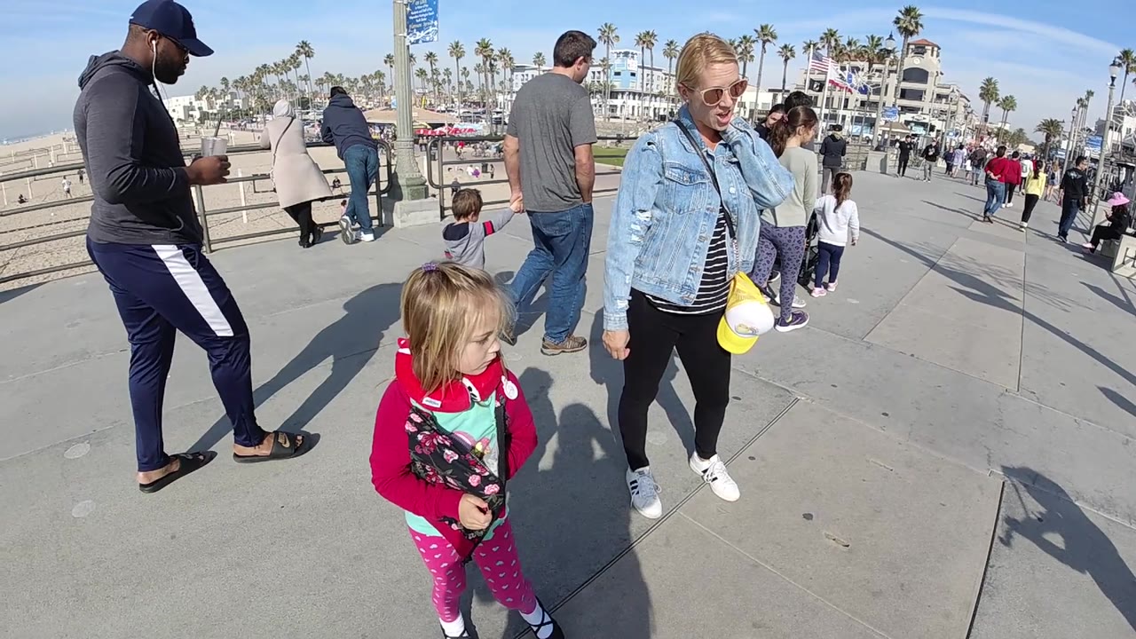 Family group paused on a crowded beach walkway.