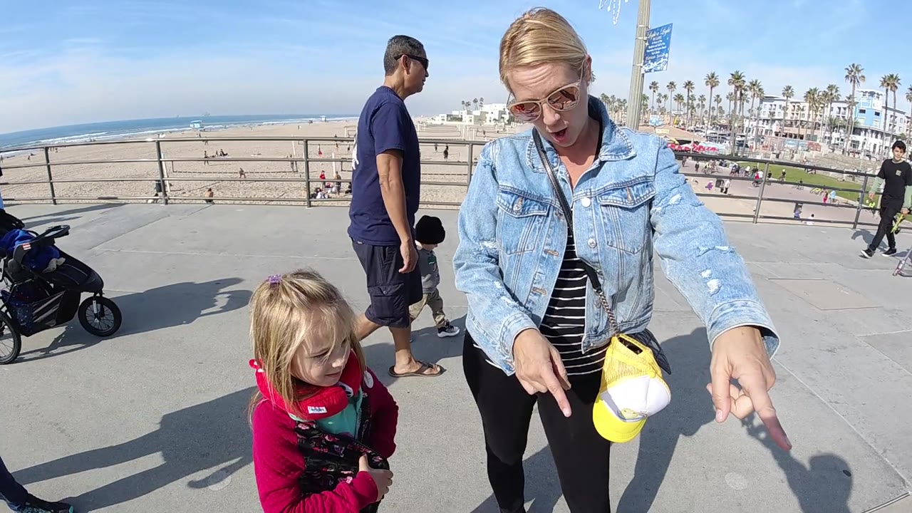 Woman points across the walkway near a toddler