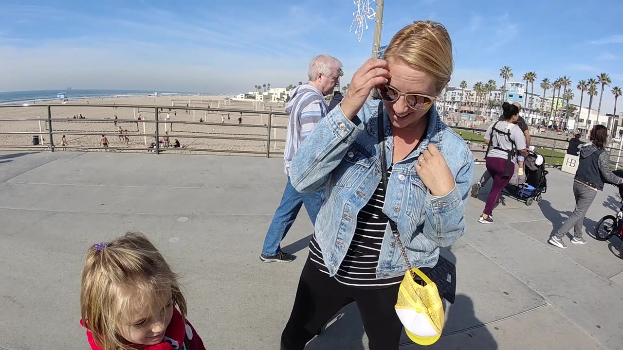 Woman and child on concrete walkway above the beach.