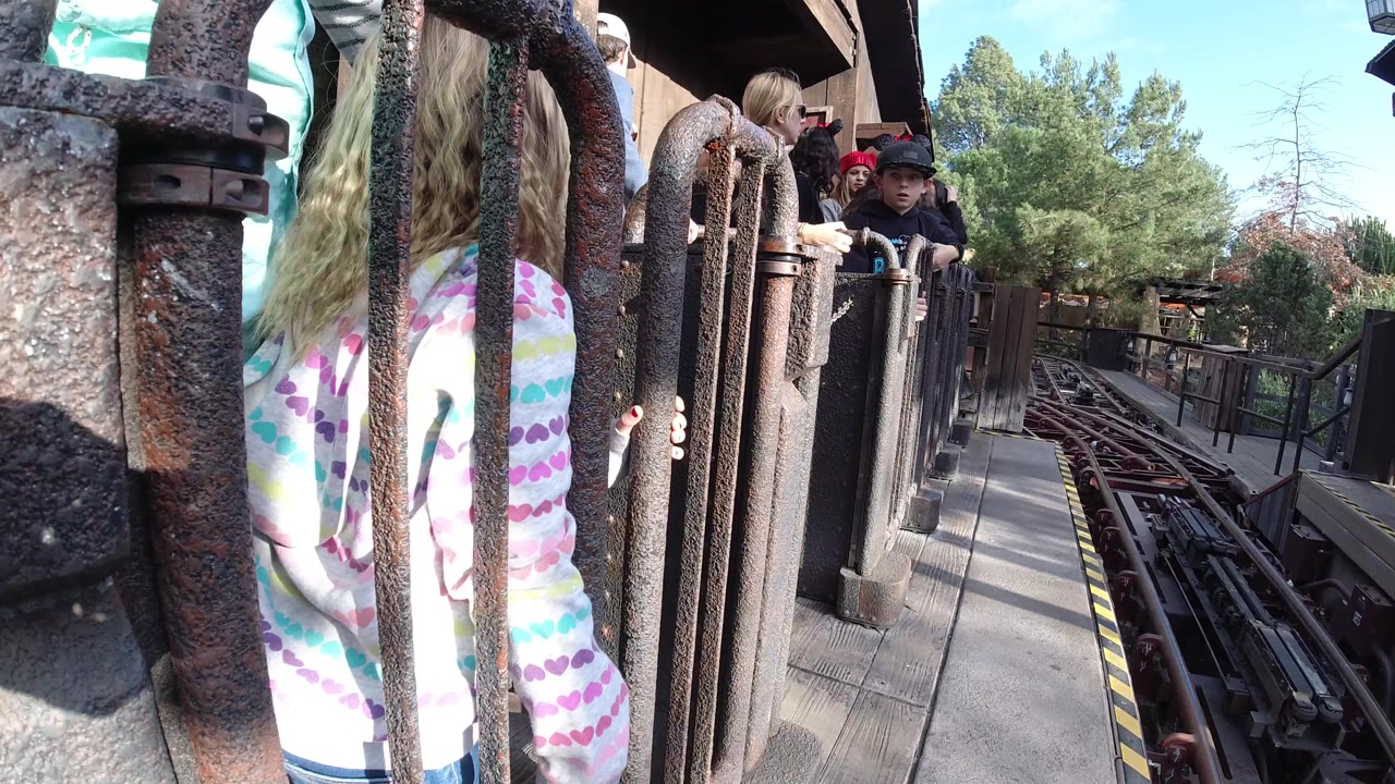 Child at gate with visitors waiting behind her