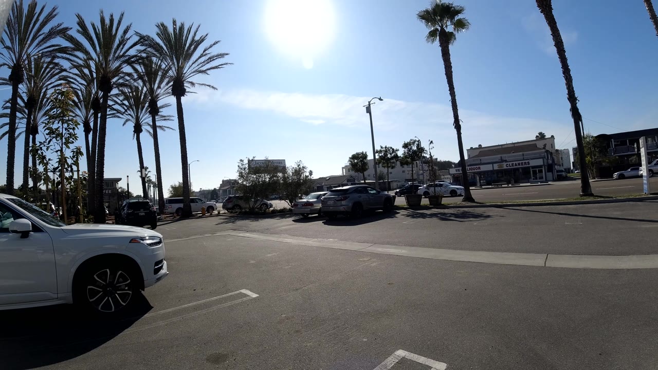Wide parking lot view with cars under bright sky