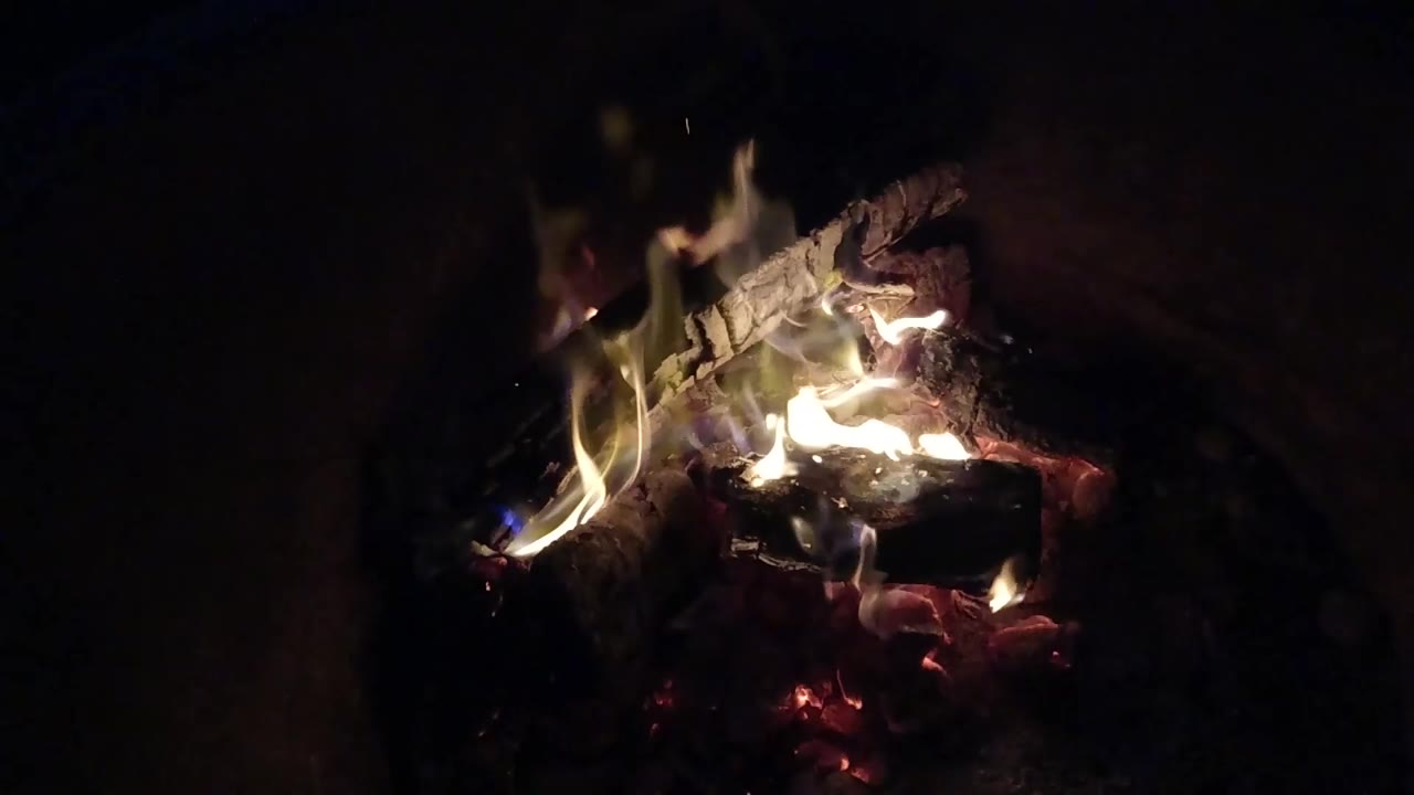 At 0:01, brighter flames curl over the top of burned wood in the Pismo Beach, California footage, with no visible people.