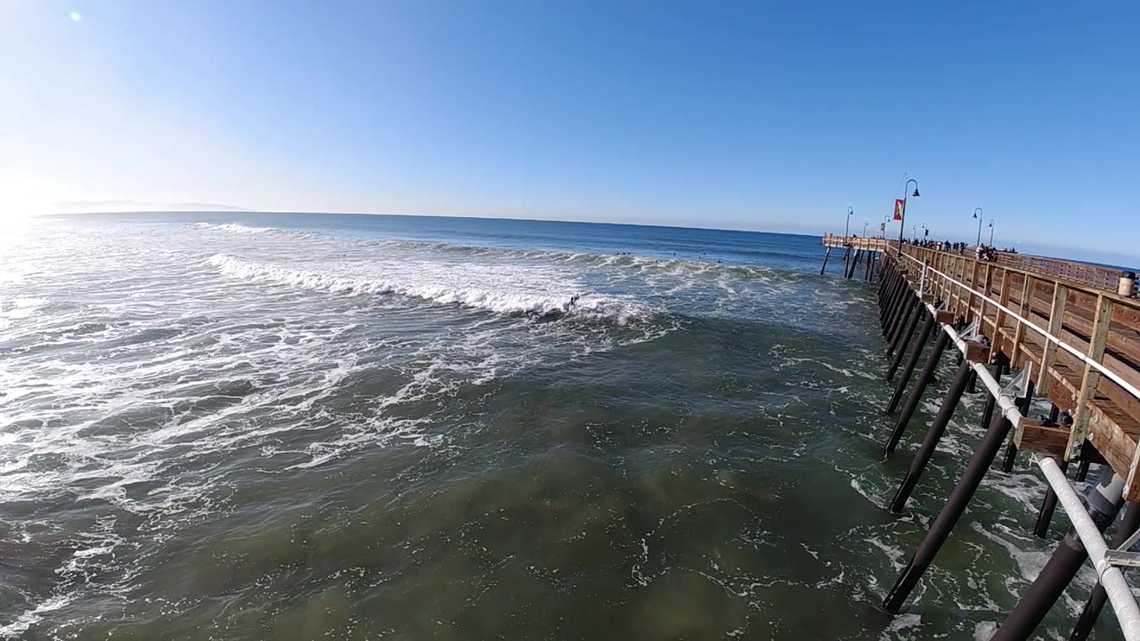 Surf line crossing open water beside the pier.