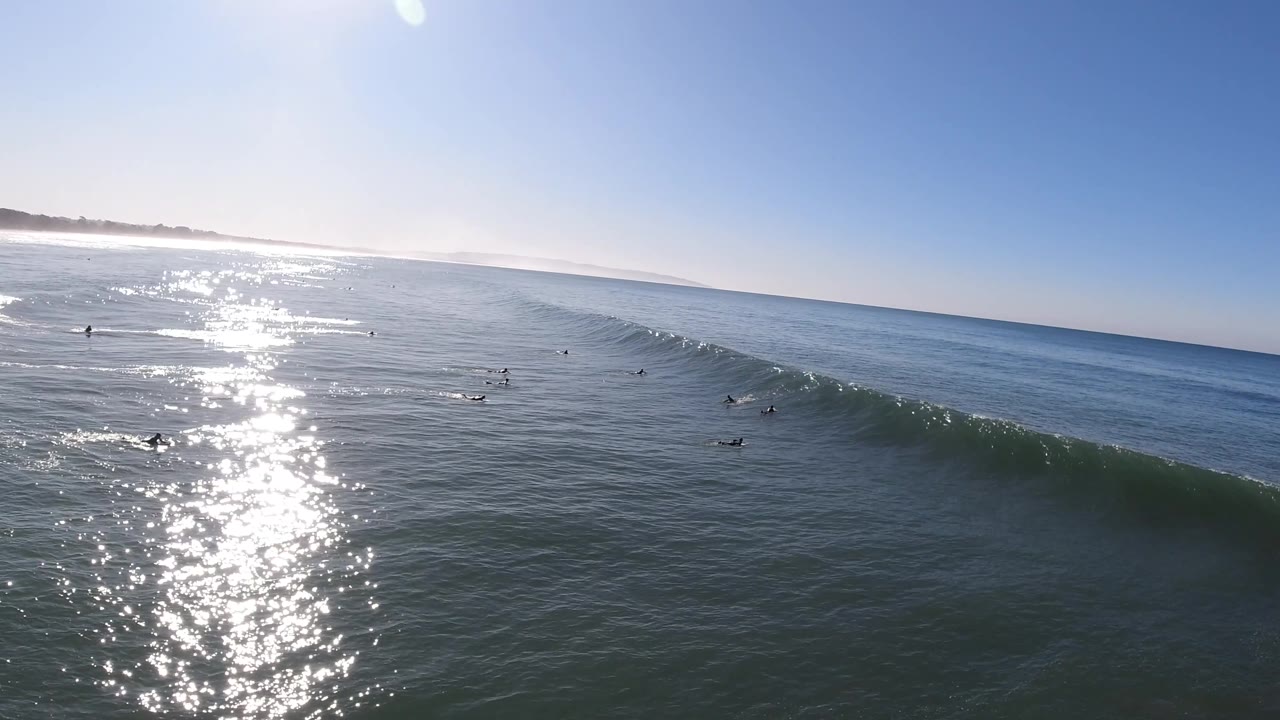Wave face rises near surfers in open ocean