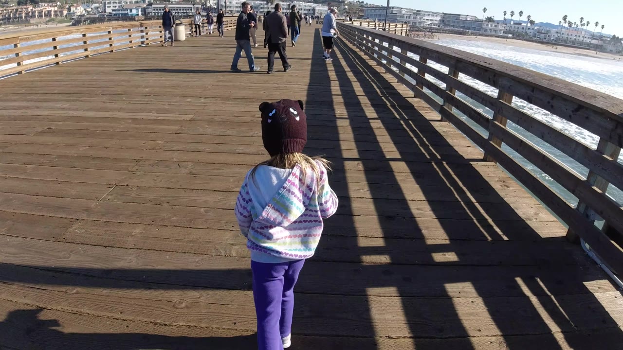 Child centered on pier with people ahead.