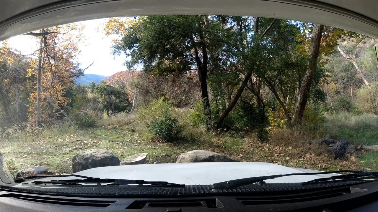 At two seconds, the parked vehicle foreground remains visible while the Ojai trees and bushes fill the midground under bright daylight, with no visible people.
