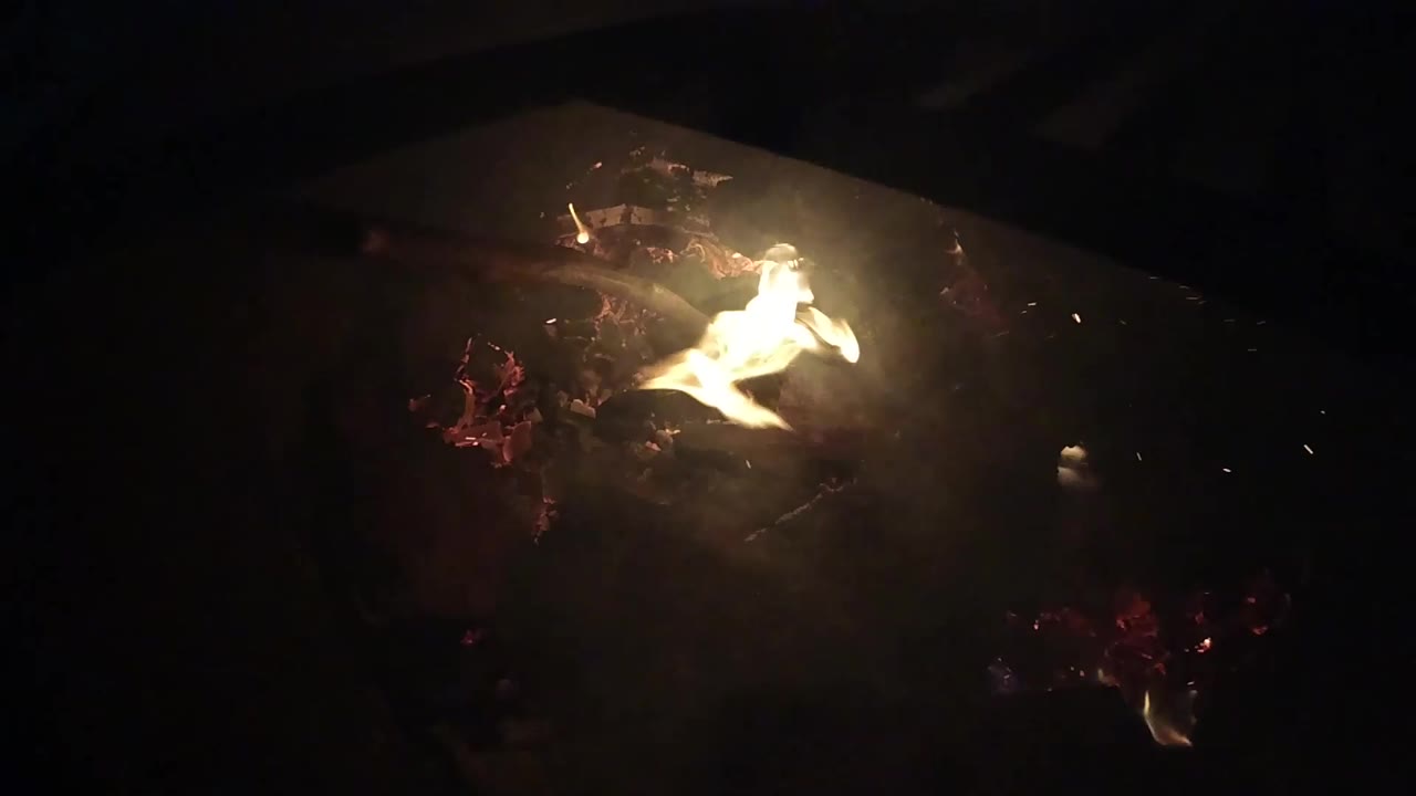 White-orange flame stretches across glowing embers in the Ojai fire shot, with black negative space around it and no visible people.