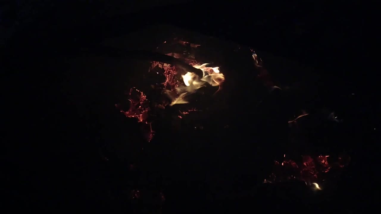 At 0:03, a low flame crosses the left side of the red embers and charred wood in Ojai, California, with no visible people.
