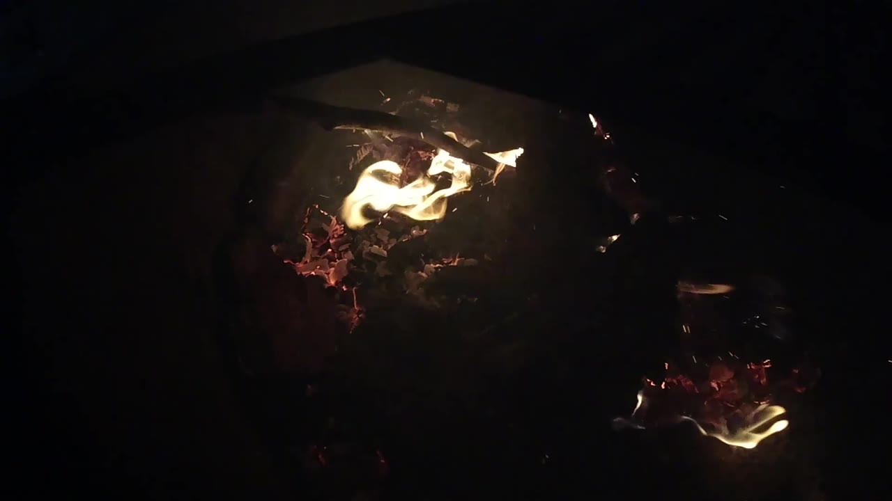 Two seconds in, the brightest flame shifts toward the upper right over a red ember bed in the Ojai night scene, with no clearly visible people.