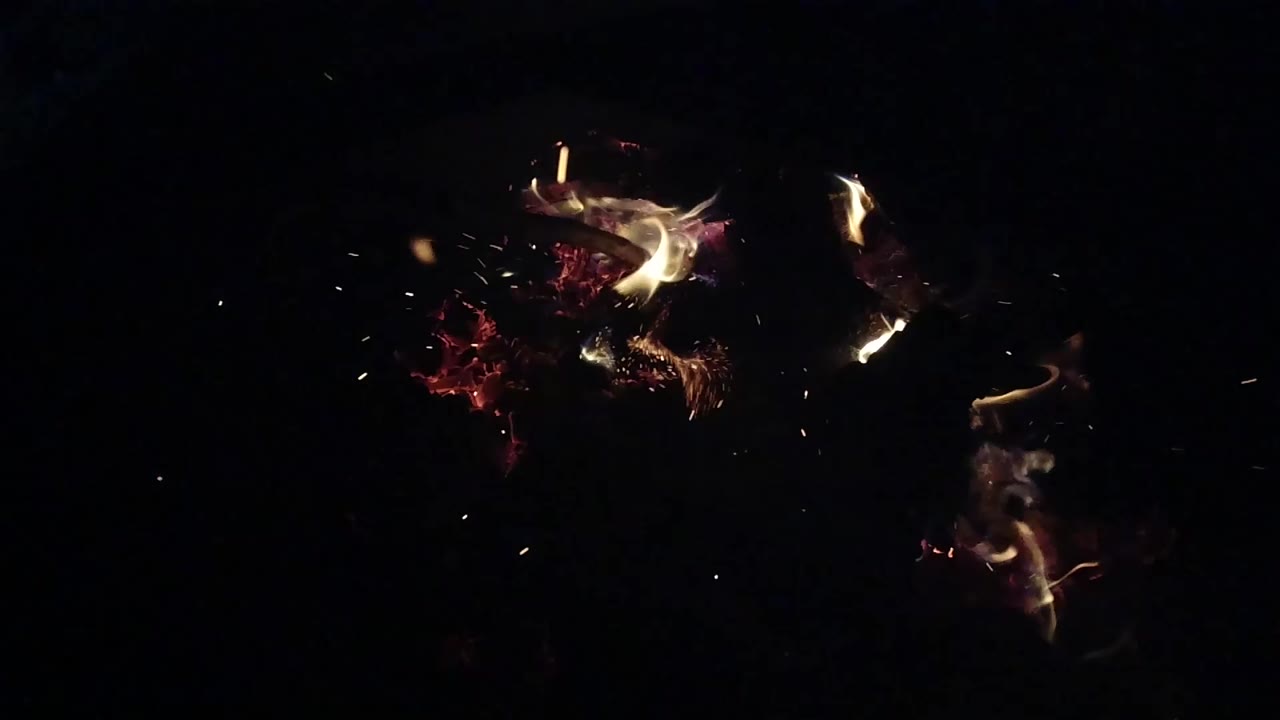 At 0:00, small red embers and pale flames burn against deep darkness in Ojai, California, with no visible people.