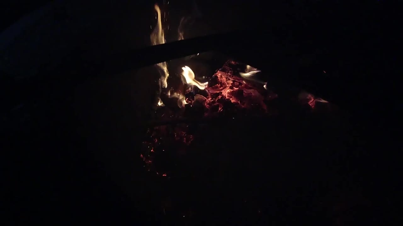 At 0:03, a brighter tongue of flame curls up from the glowing embers in the Ojai fire detail, surrounded by deep black space and no visible people.
