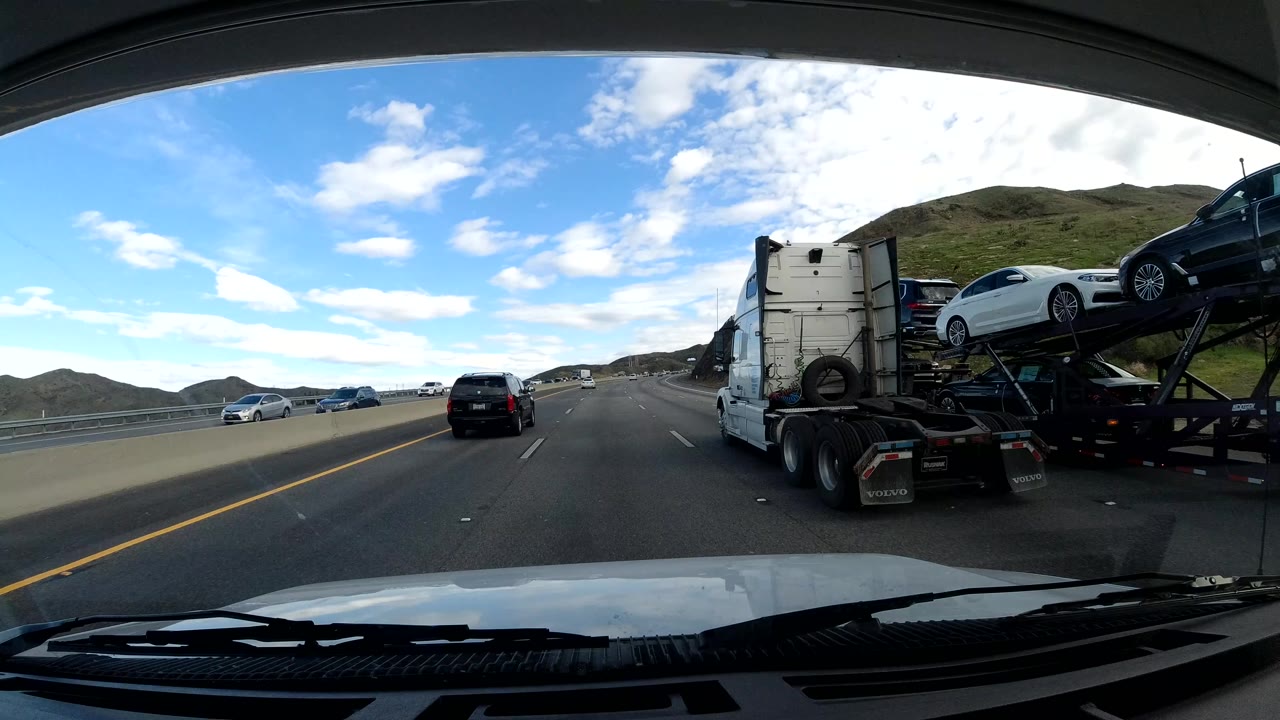 Car carrier truck beside the dashcam vehicle on the highway.