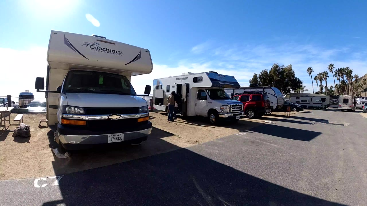 Class C motorhome and camper vans parked in a crowded lot