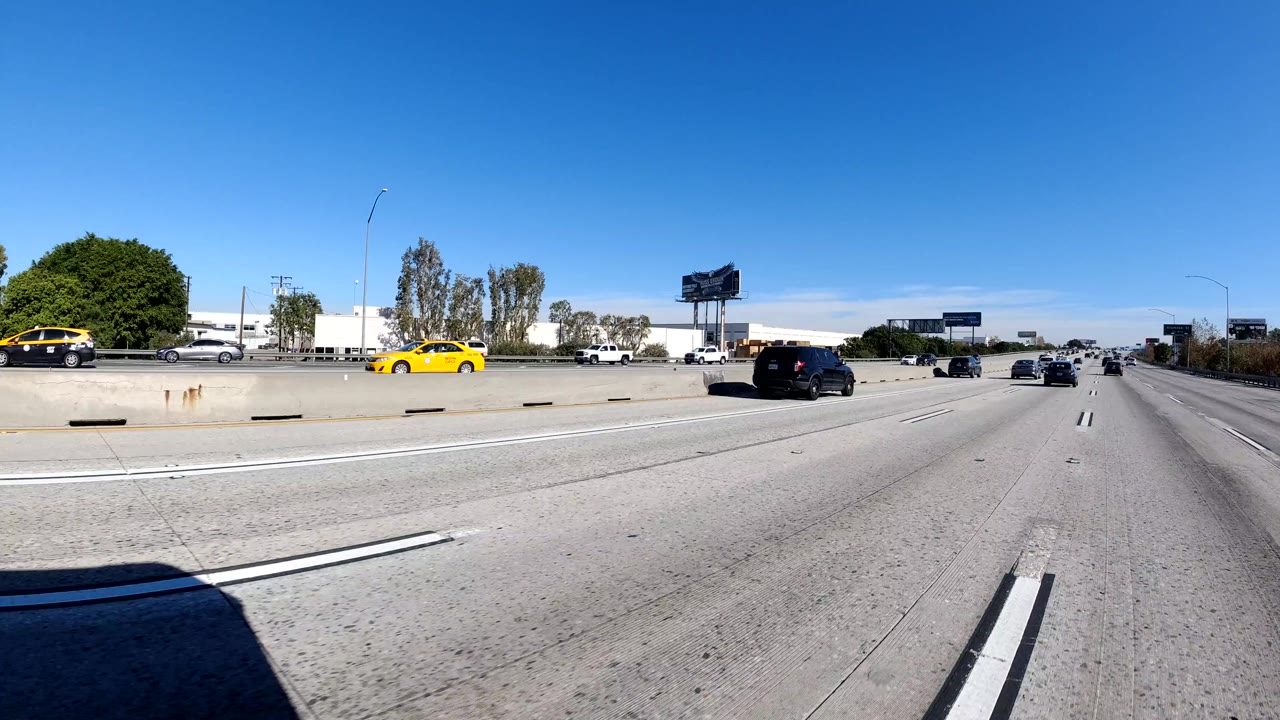 Freeway traffic with a yellow car near the median