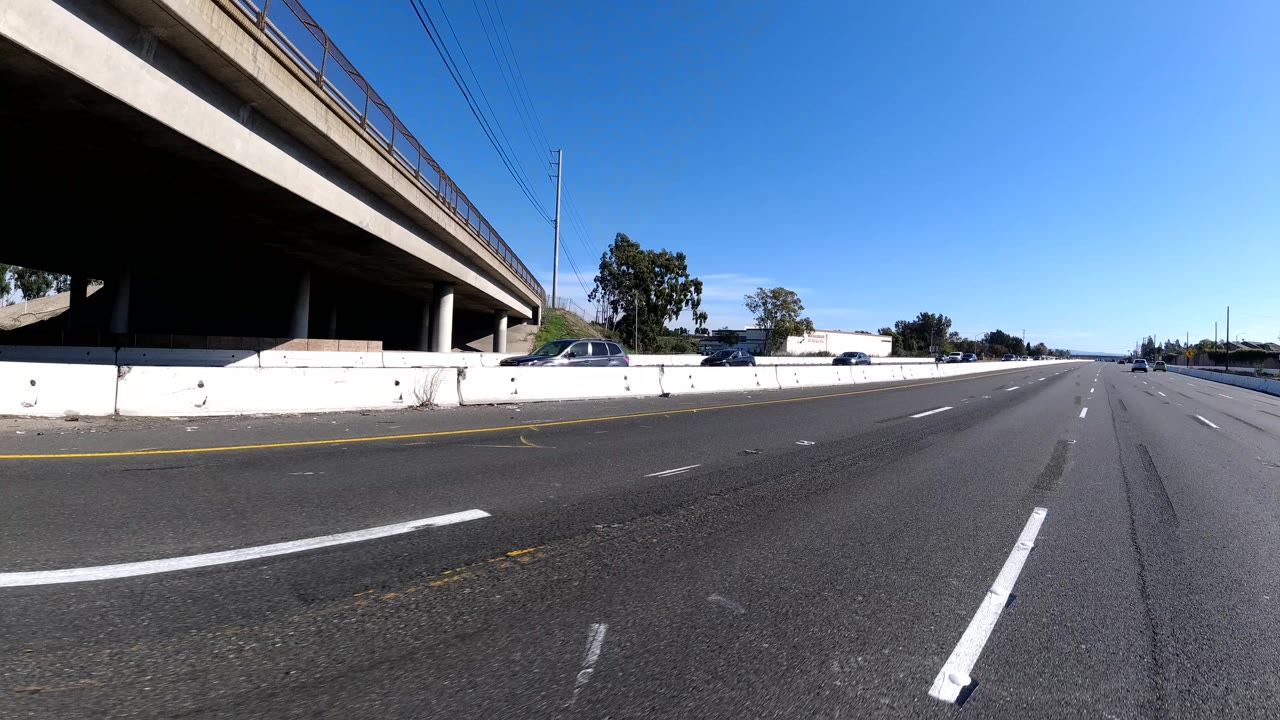 Freeway lanes running under a large overpass.