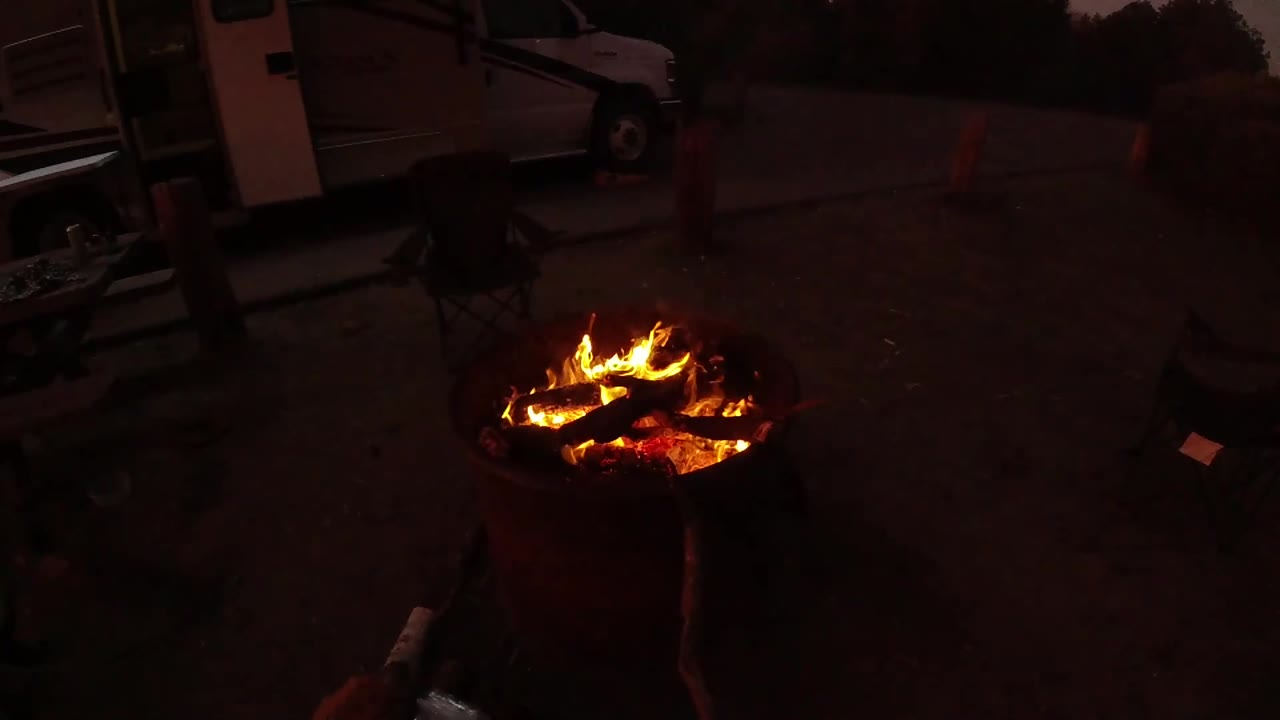 At 0:02 in San Clemente, California, the flames spread across the fire pit, with glowing embers below and the van shape anchored behind the scene.