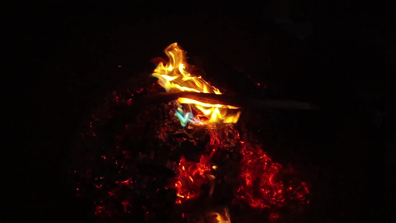 Orange and yellow flames cross a dark charred piece above red embers in the San Clemente, California clip, with no visible people.