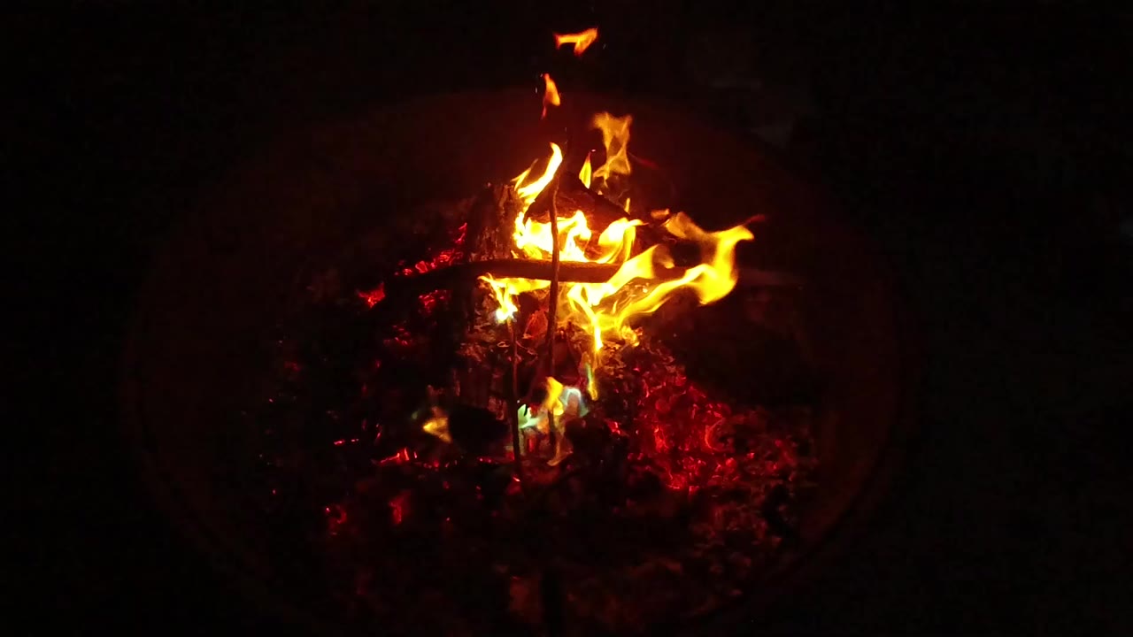 At 0:01, the flame cluster spreads across charred wood and glowing embers in San Clemente, California, with no visible people.