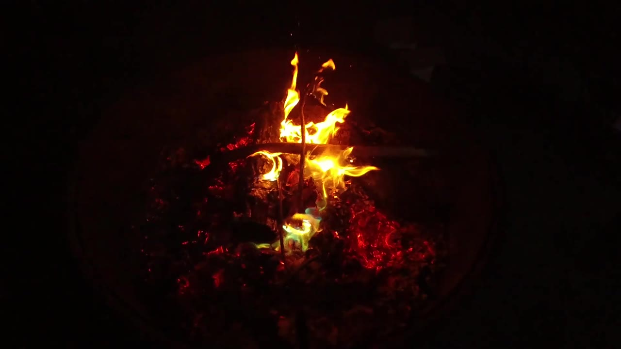 At 0:02, taller flames rise from a compact ember bed in the San Clemente, California footage, with no visible people.