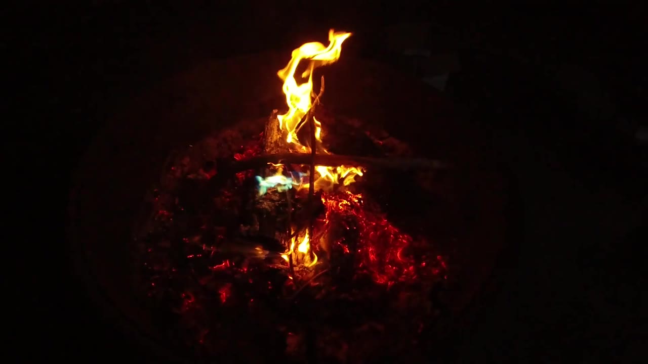 Bright flame leaning over a bed of embers.