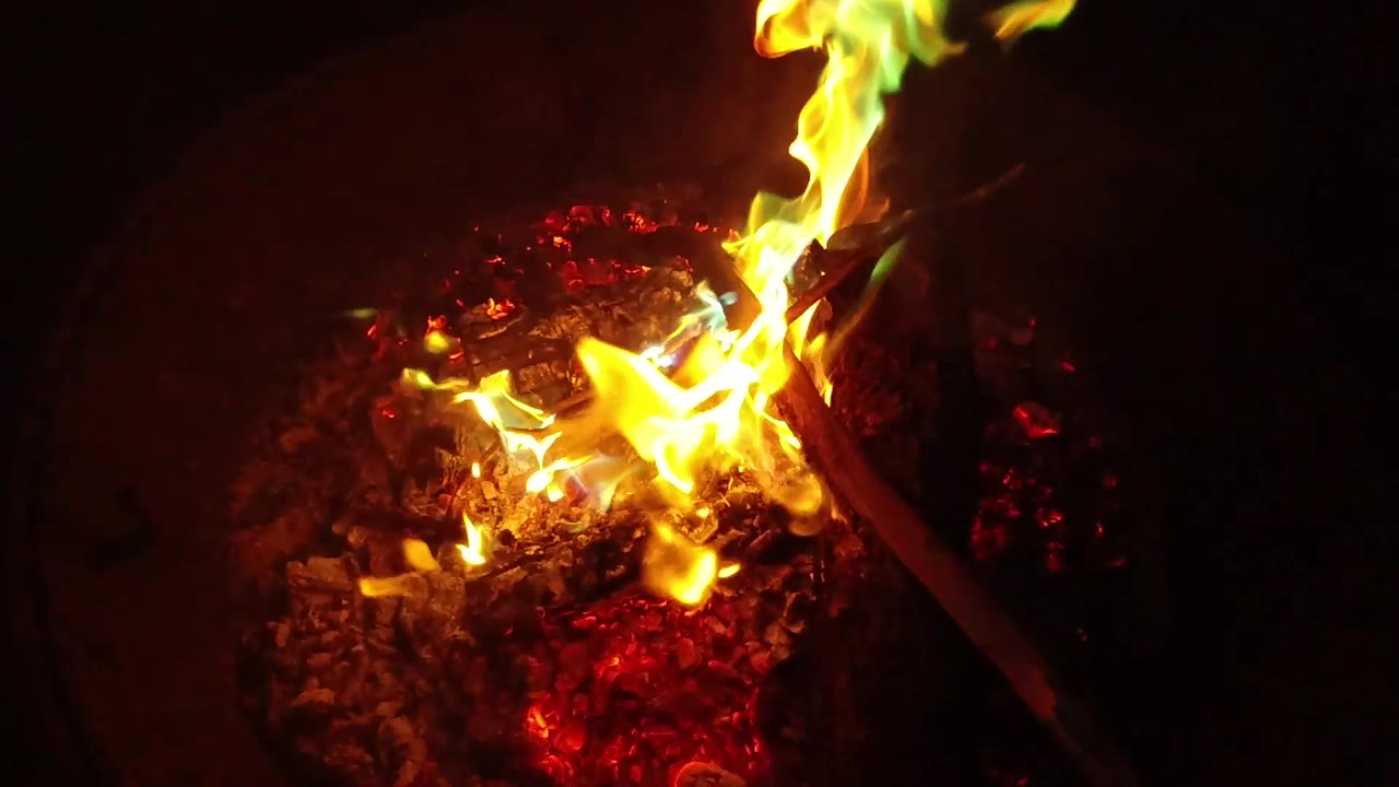 At 0:03, lower yellow flames spread across the coals while a vertical flame rises at the top edge of the San Clemente brazier, with no visible people.