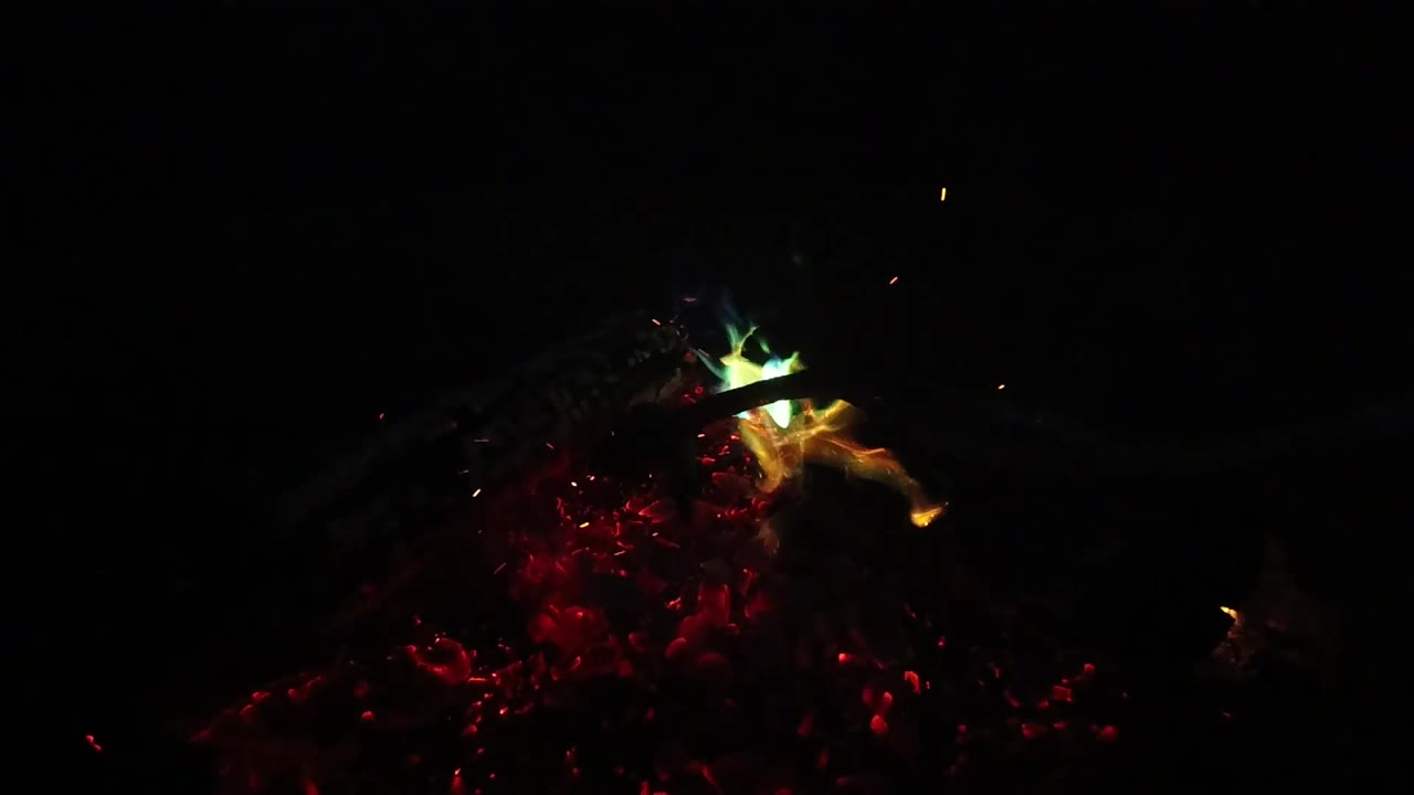 Small green and yellow flame patches sit above a red glowing base of foliage or embers in San Clemente, California, with no visible people.