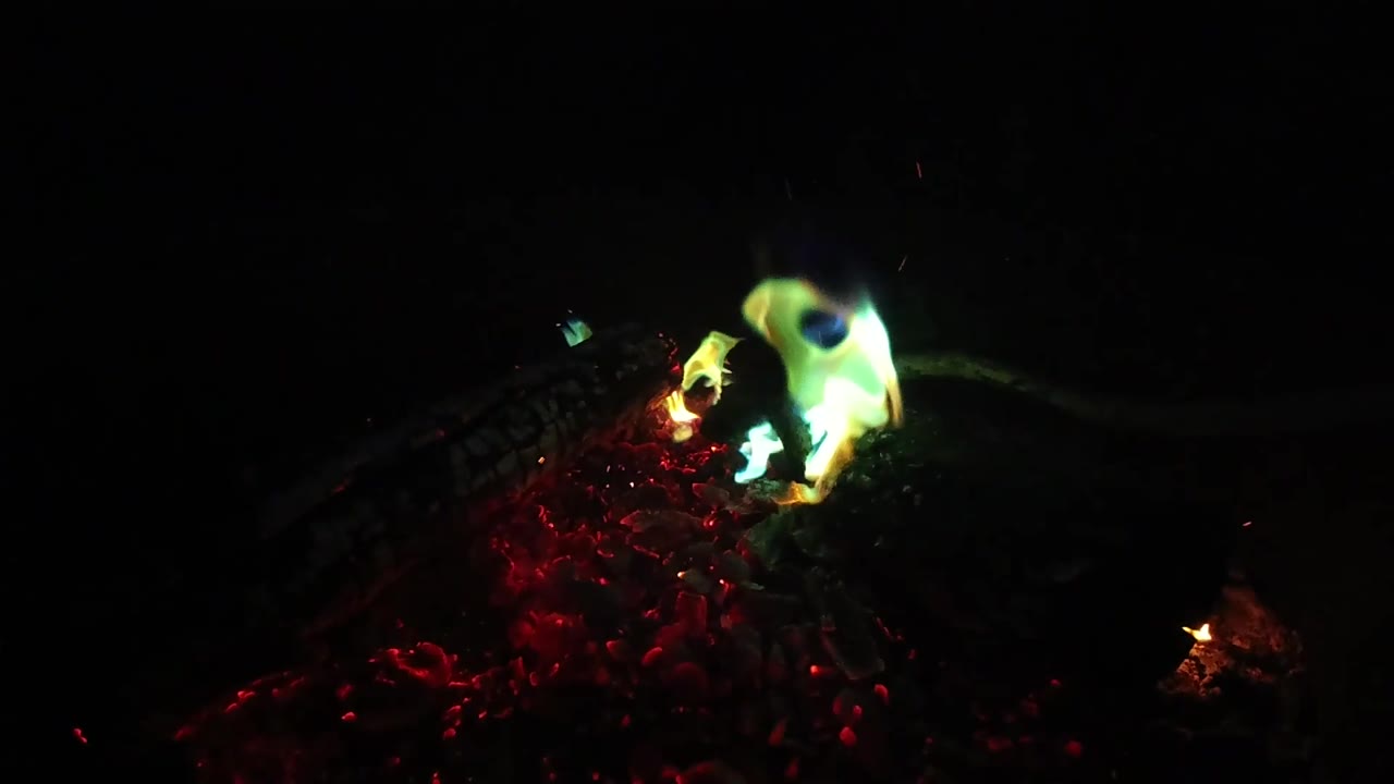 At two seconds, the San Clemente fire clip shows a brighter green and blue flame rising from red embers, with black negative space and no visible people.